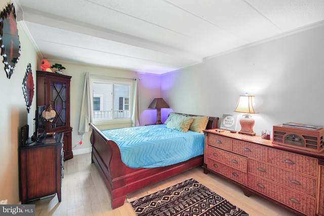 bedroom featuring ornamental molding and light hardwood / wood-style floors