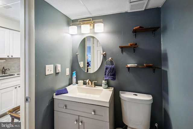 bathroom with vanity, toilet, and decorative backsplash