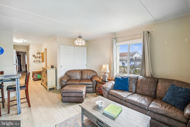 living room with light hardwood / wood-style flooring and crown molding