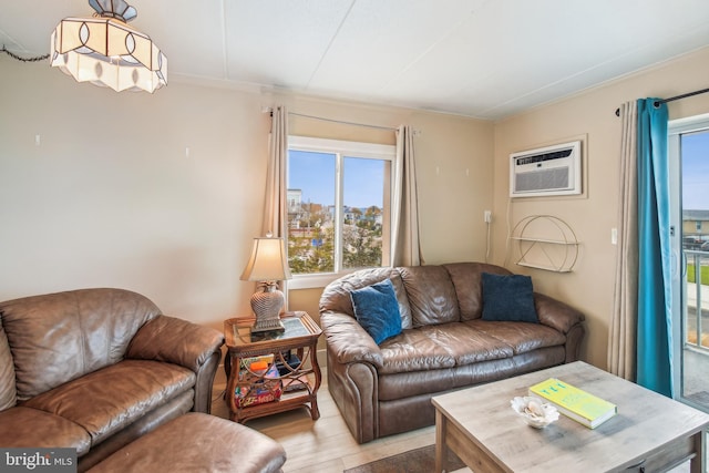 living room with an AC wall unit and light hardwood / wood-style floors