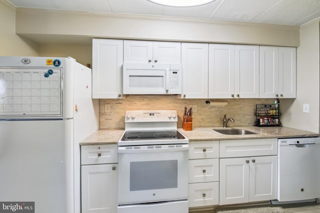 kitchen with light stone counters, sink, white cabinets, decorative backsplash, and white appliances