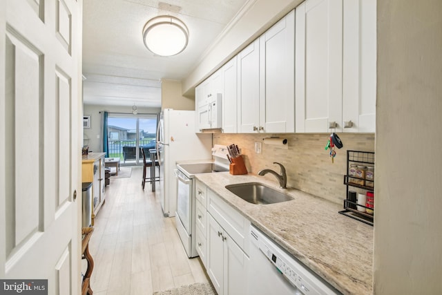 kitchen featuring backsplash, white cabinets, white appliances, and sink