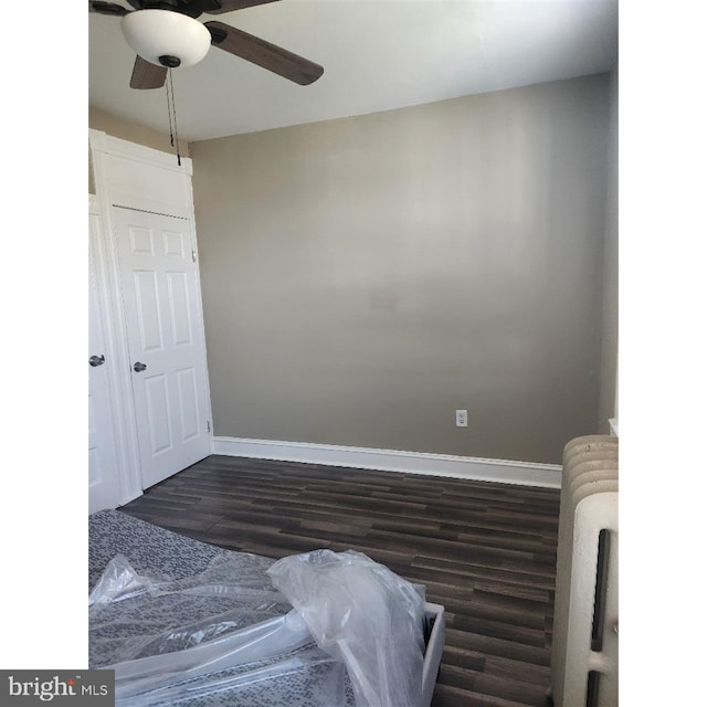 bedroom featuring radiator heating unit, ceiling fan, and dark wood-type flooring