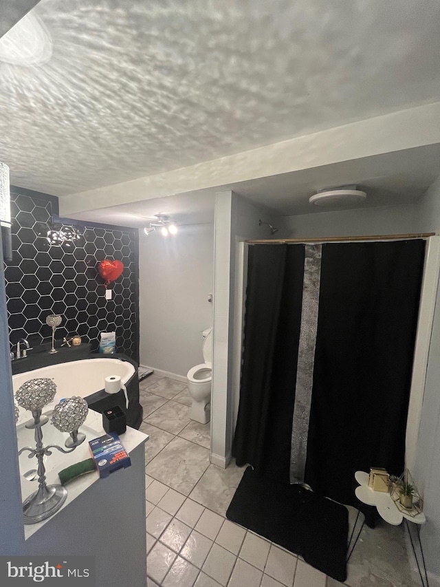 bathroom with a shower with curtain, a textured ceiling, and toilet