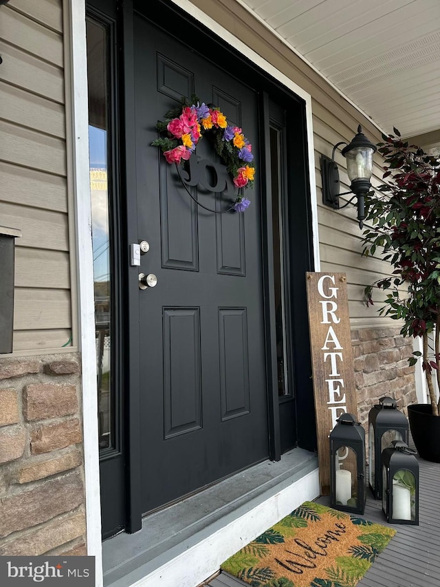 view of exterior entry featuring covered porch