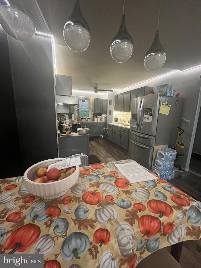 interior space featuring dark hardwood / wood-style floors and stainless steel fridge with ice dispenser