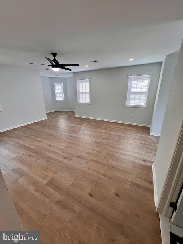 spare room with light wood finished floors, recessed lighting, visible vents, a ceiling fan, and baseboards