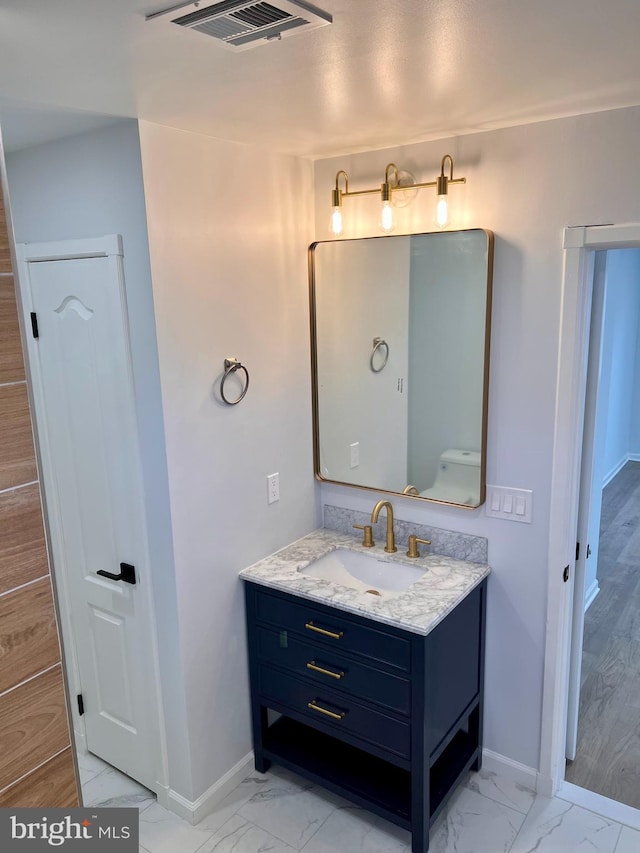 bathroom with marble finish floor, visible vents, vanity, and baseboards