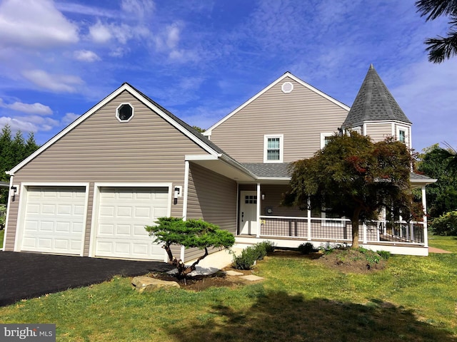 view of front of home featuring a garage, a front lawn, and covered porch