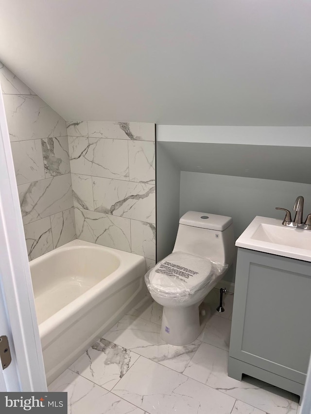 full bathroom with marble finish floor, lofted ceiling, toilet, vanity, and a bath