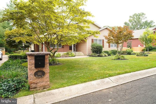 obstructed view of property featuring a front lawn