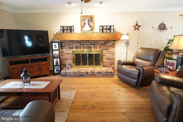 living room featuring a brick fireplace, crown molding, and light hardwood / wood-style floors