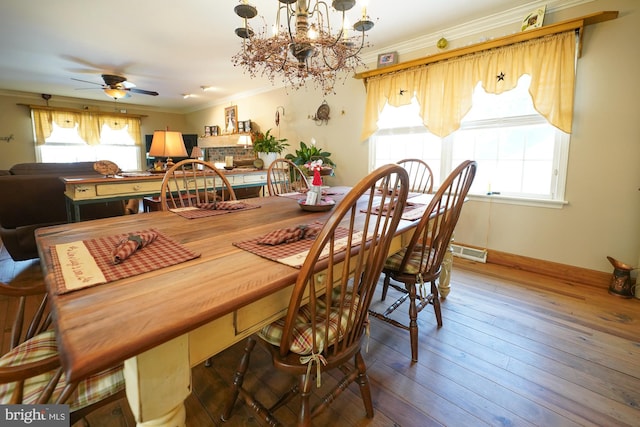 dining area with wood-type flooring, ceiling fan with notable chandelier, and crown molding