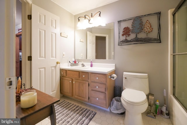 full bathroom with combined bath / shower with glass door, tile patterned floors, vanity, and toilet