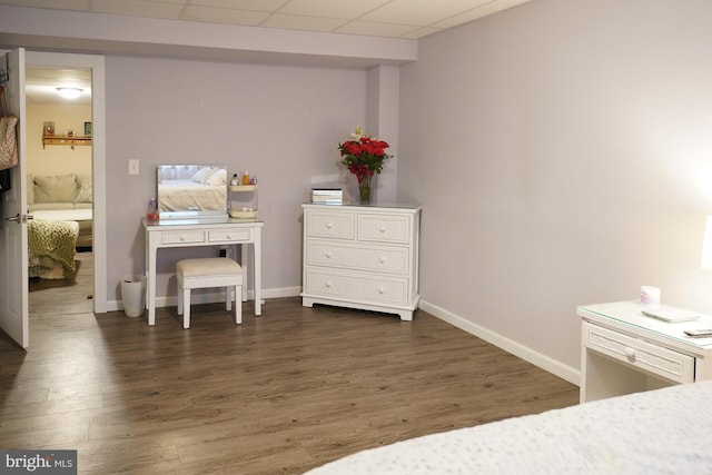 bedroom featuring a drop ceiling and dark hardwood / wood-style flooring