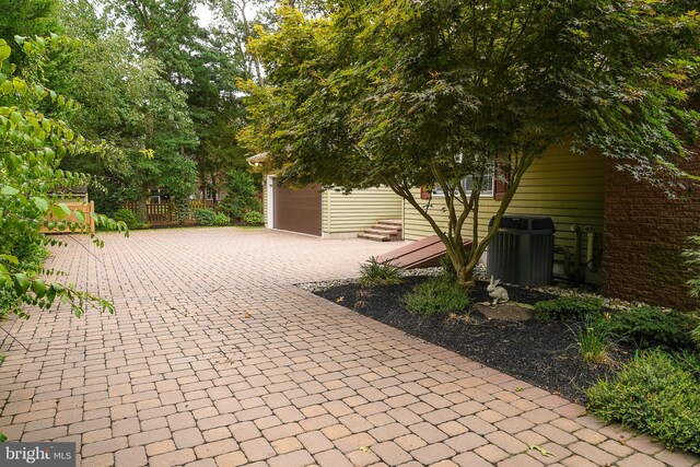 view of patio featuring central AC unit and a garage