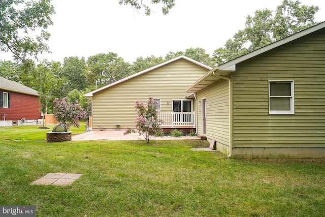 rear view of house featuring a yard and a patio area