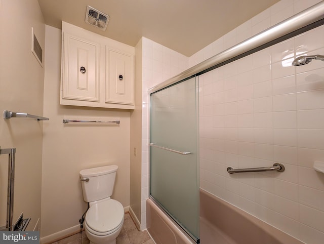 bathroom with tile patterned floors, visible vents, toilet, and bath / shower combo with glass door