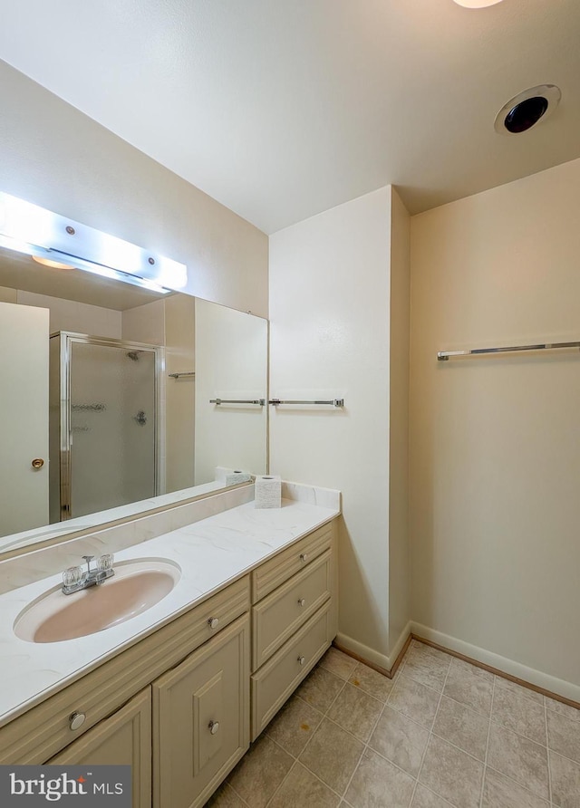 full bathroom featuring a shower stall, baseboards, tile patterned flooring, and vanity