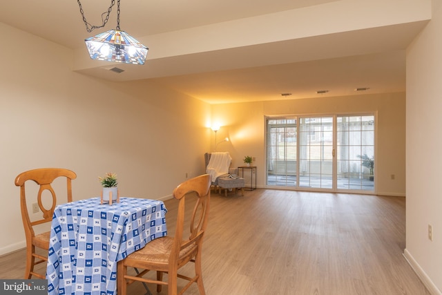 dining space featuring baseboards and wood finished floors