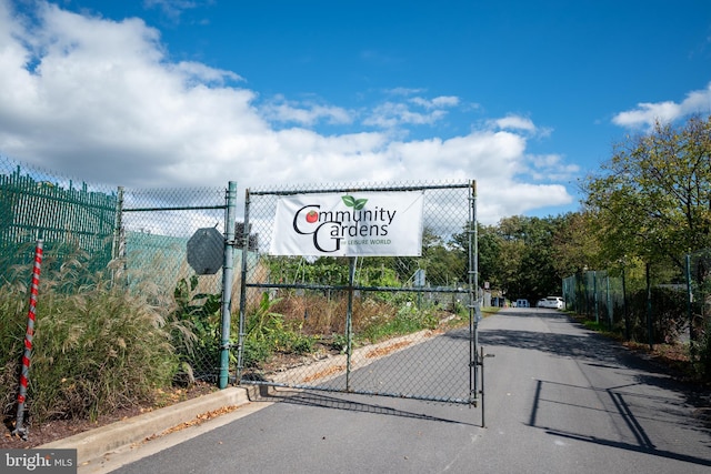 view of road featuring a gate and curbs