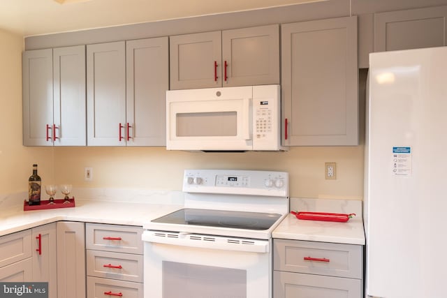 kitchen with white appliances and gray cabinetry