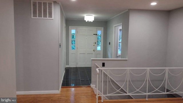 foyer entrance with crown molding and wood-type flooring