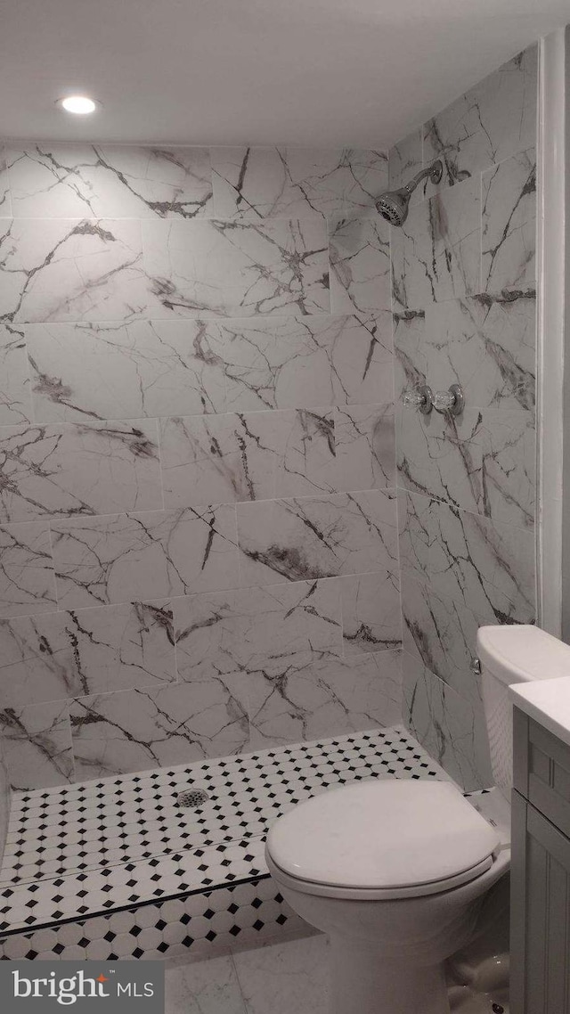 bathroom featuring tiled shower, vanity, and toilet