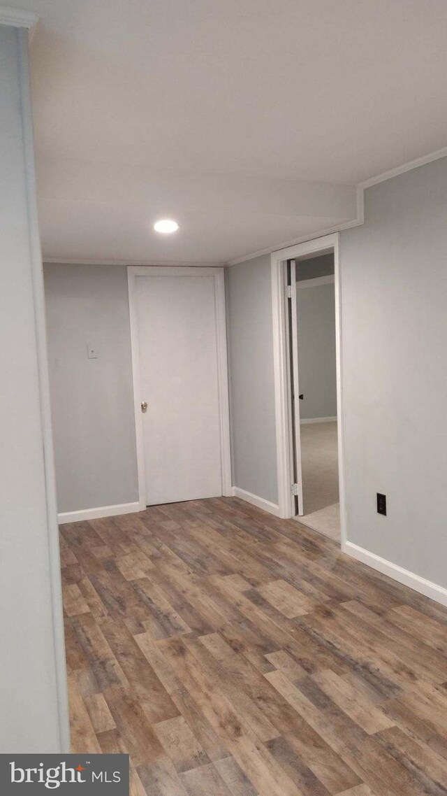 empty room with hardwood / wood-style floors and ornamental molding