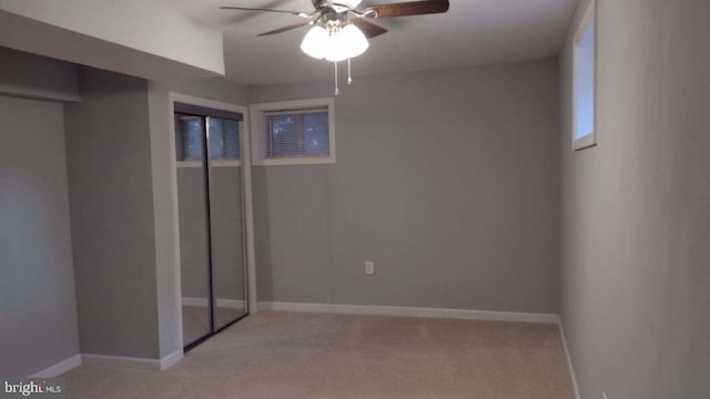 unfurnished bedroom featuring light carpet, a closet, and ceiling fan