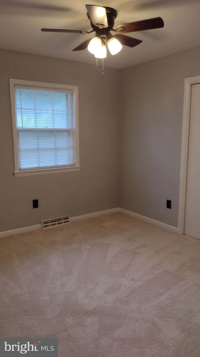 carpeted spare room with ceiling fan