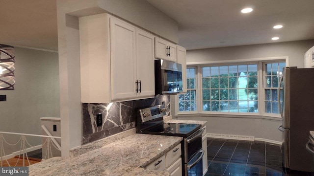 kitchen featuring white cabinets, light stone countertops, backsplash, and appliances with stainless steel finishes