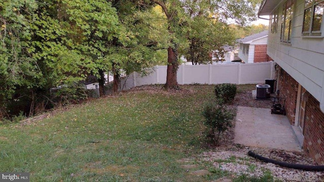 view of yard with central air condition unit and a patio