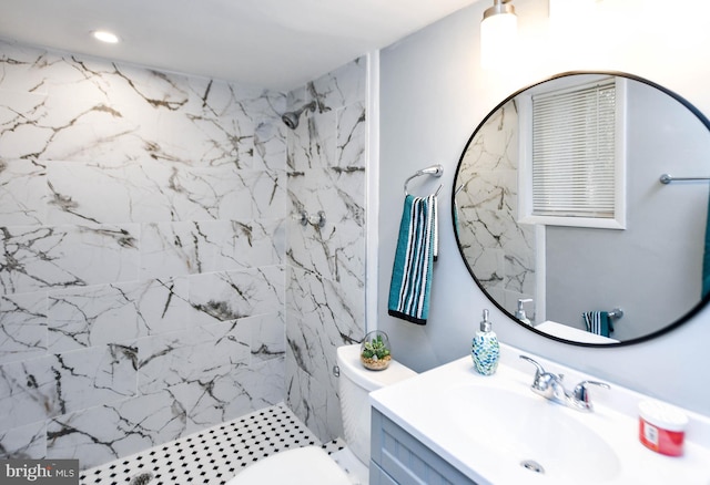 bathroom featuring tiled shower, vanity, and toilet