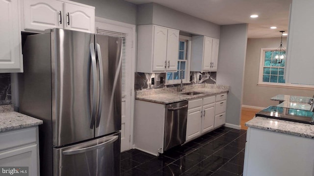 kitchen featuring decorative backsplash, white cabinetry, sink, and appliances with stainless steel finishes