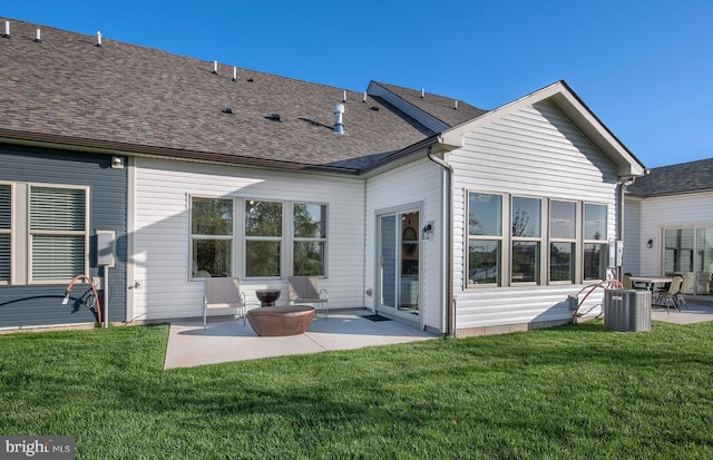 back of property with central AC unit, a lawn, and a patio area