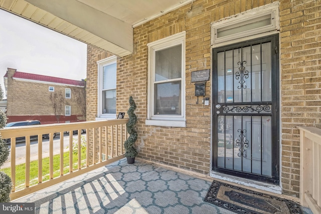 view of exterior entry featuring covered porch