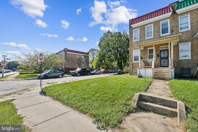 townhome / multi-family property featuring a porch and a front lawn