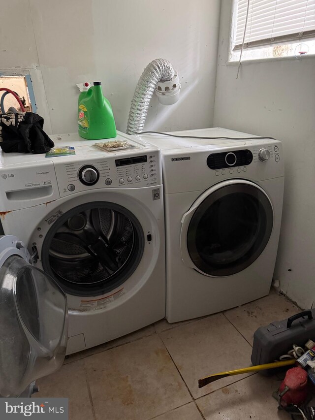 laundry room with washer and clothes dryer and light tile patterned flooring