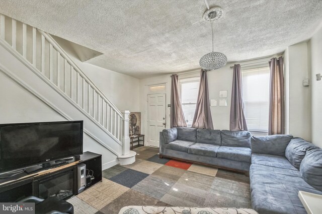 living room featuring a textured ceiling and dark wood-type flooring