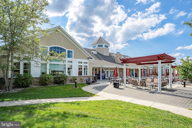 view of home's community with a pergola, a patio area, and a yard