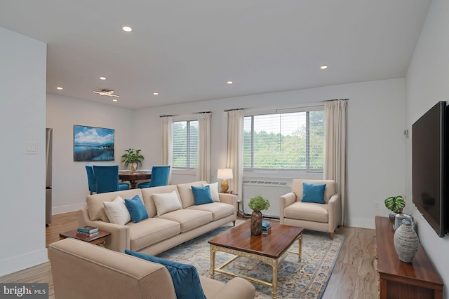 living room with light hardwood / wood-style flooring and radiator heating unit