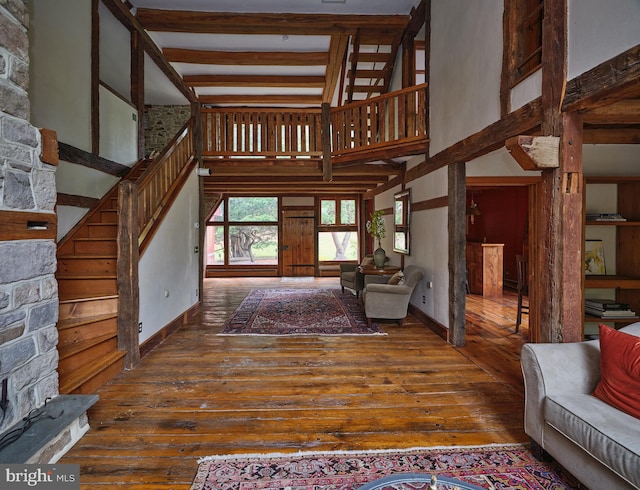 interior space with a high ceiling, beamed ceiling, and dark hardwood / wood-style flooring