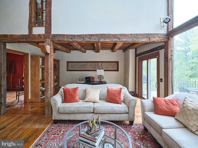 living room featuring beam ceiling and dark hardwood / wood-style flooring