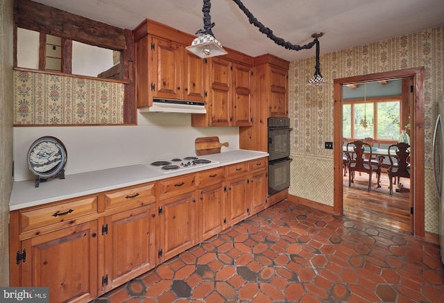 kitchen featuring pendant lighting, white electric stovetop, double oven, and dark wood-type flooring