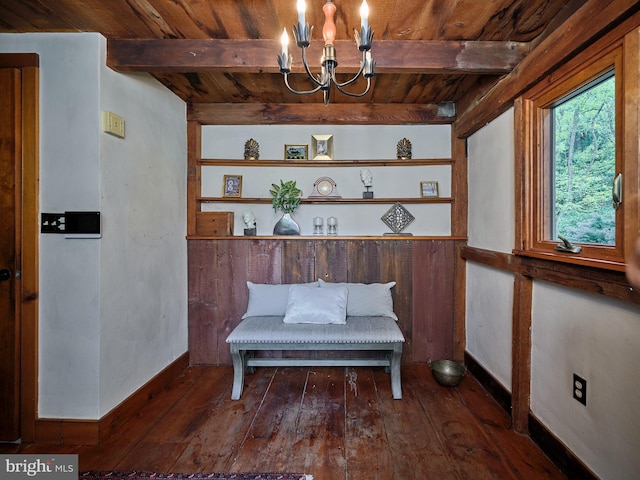 sitting room featuring an inviting chandelier, beam ceiling, dark wood-type flooring, and wooden ceiling