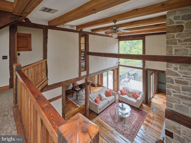 living room featuring ceiling fan, beamed ceiling, and light hardwood / wood-style flooring