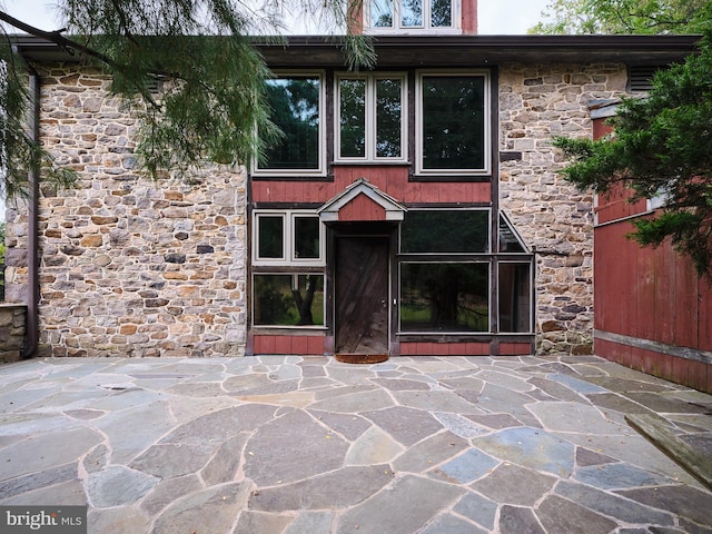 view of exterior entry with a patio area