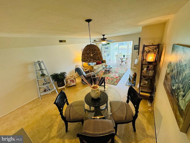 dining room featuring ceiling fan and a textured ceiling