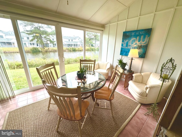 sunroom featuring a water view, a wealth of natural light, and lofted ceiling